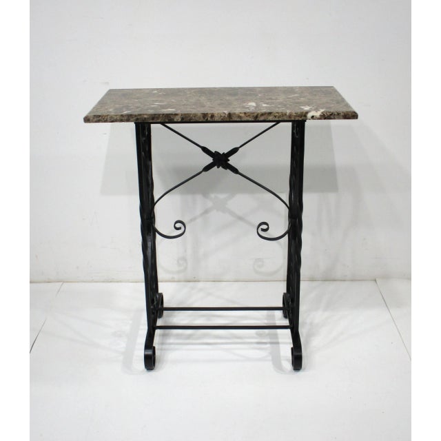 A very nice beveled marble topped console table with handcrafted sculptural black iron base having twisted and curved...