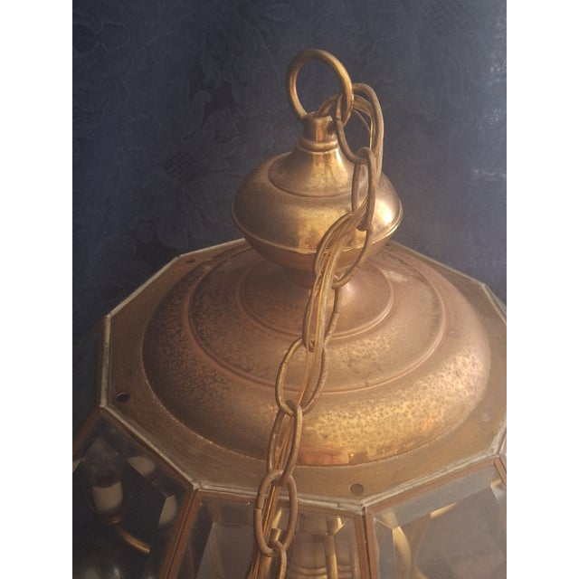 Elegant vintage lantern-style chandelier featuring an octagonal brass-finished frame with beveled glass panels and 10...