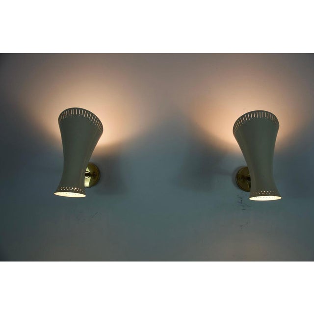 This pair of mid-century modern brass diabolo wall lamps, crafted in germany in the 1950s, embodies the elegance and...