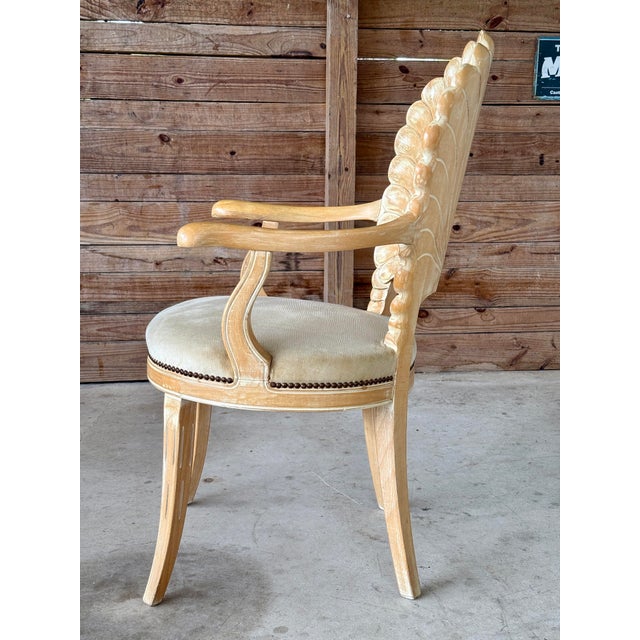 Mid-20th Century carved wood armchair featuring an intricately detailed shell back in the classic Grotto style. The chair...
