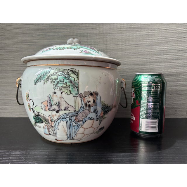 An authentic early 20th Century Chinese porcelain lidded warming pot featuring a hand-painted Famille Rose scene of...