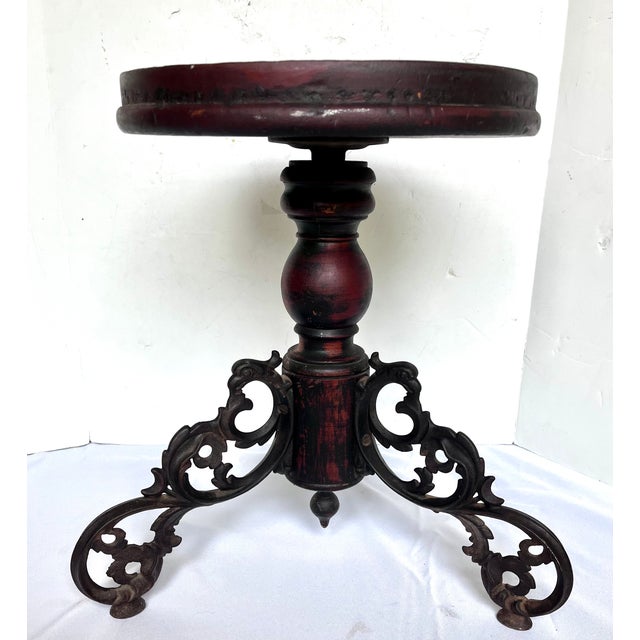 Early 1900s dark wood piano stool with ornate cast iron tripod legs. Beautifully aged wood patina. Versatile furnishing...