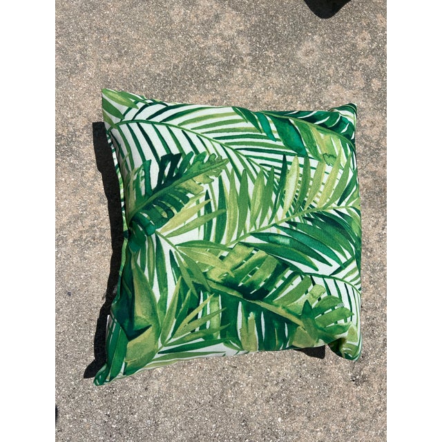 Pair of tropical palm leaf pattern throw pillow featuring vibrant green banana and palm fronds layered over a white...