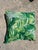 Pair of tropical palm leaf pattern throw pillow featuring vibrant green banana and palm fronds layered over a white...