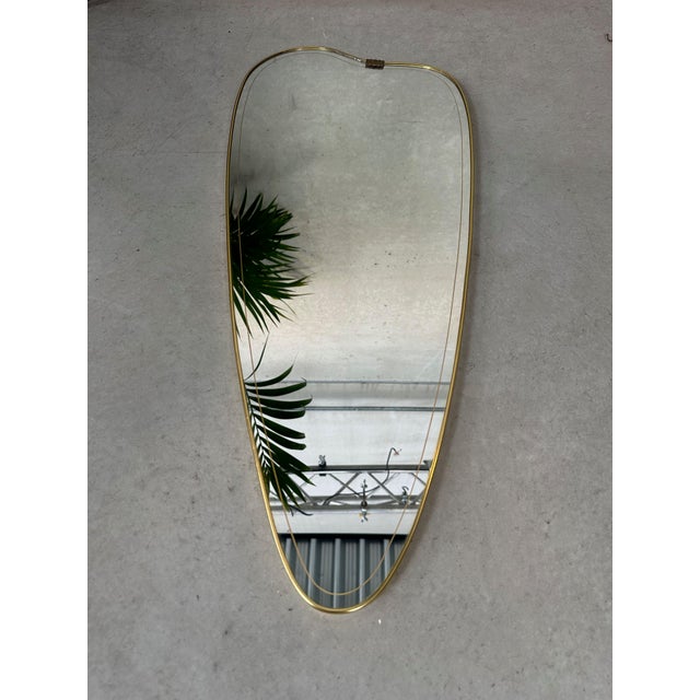 Original 1950s mirror in perfect condition. Organic, playful shape. Brass and gold-colored details. Height: 85cm. Width:...
