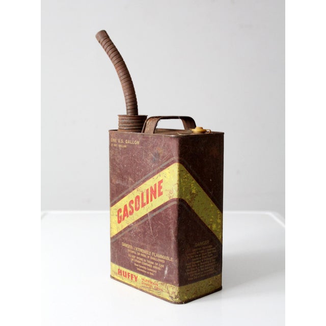 Late 1950s Huffy one-gallon metal gasoline can featuring bold diagonal graphics in deep brown and yellow. The compact...