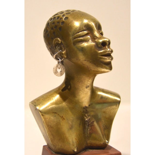 Beautiful modernist bronze bust of an African woman made in the 1940-50s. The sculpture has a shell and a chevron bead...