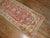A decorative turkish runner with animals outlined in light blue floating around on a red field. Measures: 3' x 11'5''.