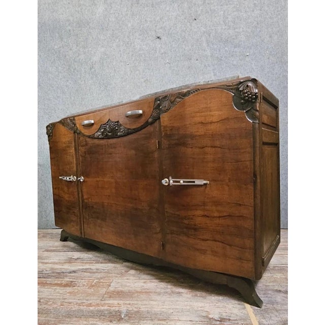 Art Deco mahogany sideboard, featuring beautiful curved lines typical of the 1930s. The piece is richly decorated with...