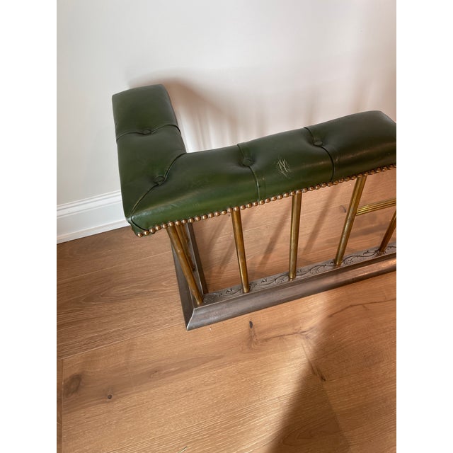 Nice English fireplace fender with a solid steel base and brass spindles. The seating is upholstered in green tufted...