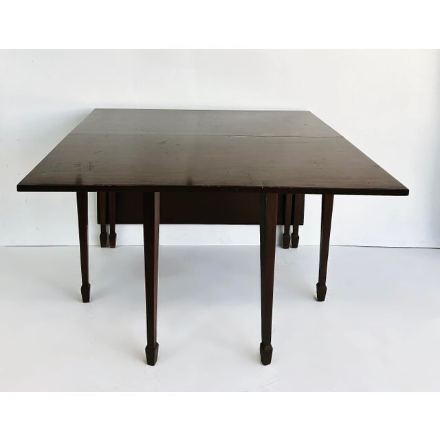 1950s Antique-Style Mahogany Drop-Leaf Gateleg Table Offered for sale is a solid mahogany table with four gatelegs that...