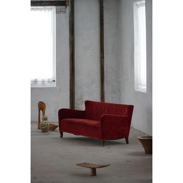 An elegant Scandinavian sofa from the early to mid-20th century, characterized by its balanced proportions, gently curved...