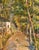 Warm and vibrant European landscape of a pathway in a wood with a building in the background. Rich and earthy color...