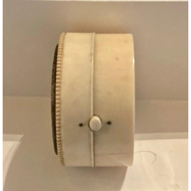 This vintage round snuff container dates from the 19th century. The round carved bone container features a decorative...