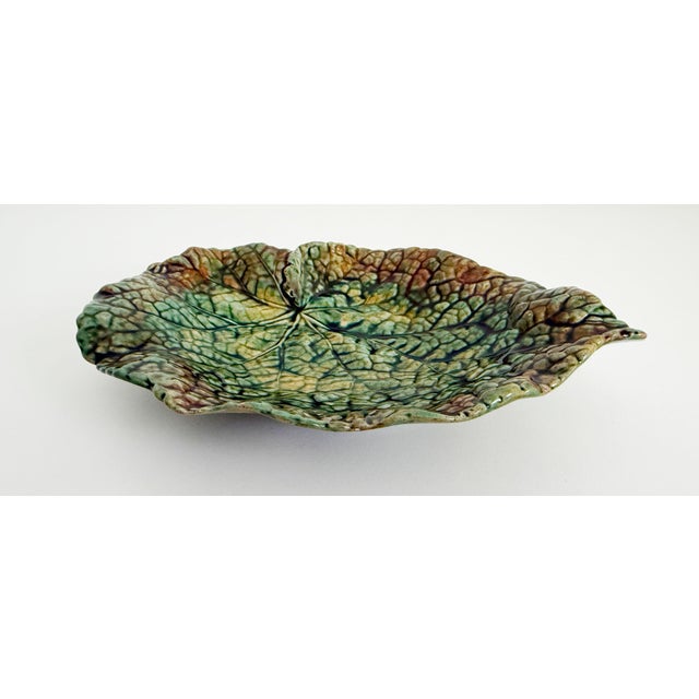 An early 20th-century English majolica stoneware dish. The shape mimics a begonia leaf, finished in verdant green glaze...