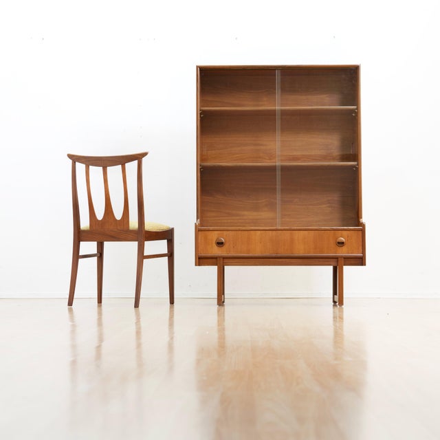This vintage mid-century china cabinet was produced in England by Turnidge of London during the 1970s. This display...