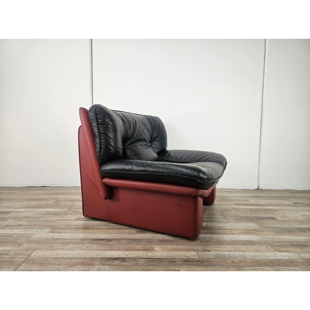 An elegant vintage armchair by Nicoletti Salotti, featuring a distinctive enveloping structure and two-tone genuine...