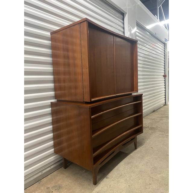 This two-piece "gentleman's chest" or armoire from Young Manufacturing is known for its distinctive concave (curved) front...
