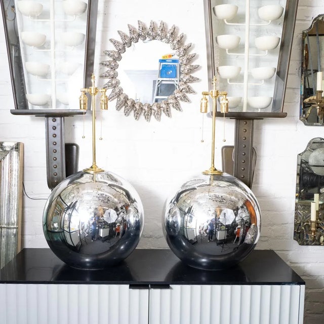 Pair of large spherical mercury glass lamps with brass hardware.
