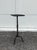 The chunky, textured tripod stand gives this square-topped drink table its slender silhouette. A laurel leaf detail in the...