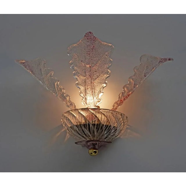 Pair of Murano glass wall sconces. Each wall lamp has a metal frame supporting a bulb, shaded by three beautiful blown...