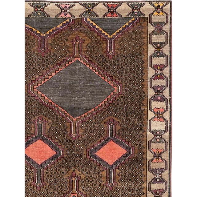 This Mid-20th century Turkish Anatolian room-size carpet presents a disciplined twin-panel composition arranged across a...