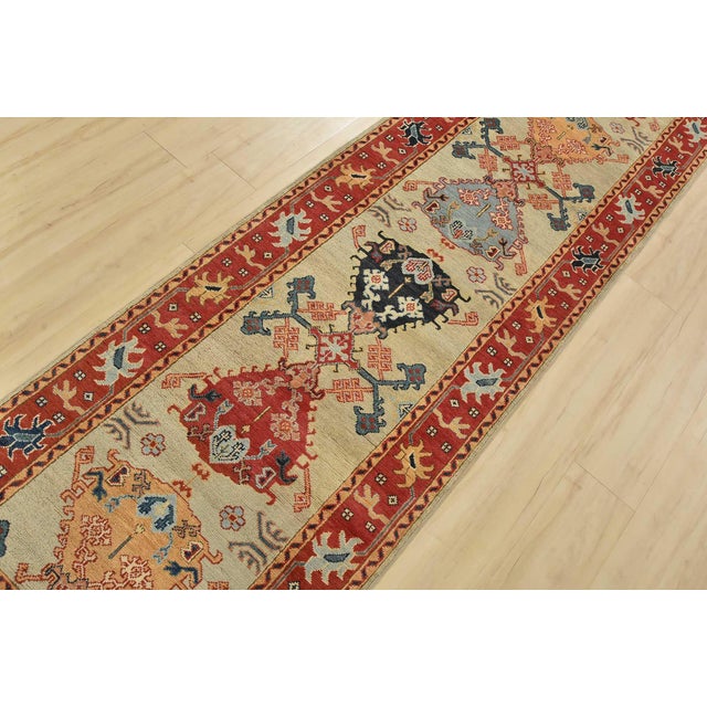 A tribal Caucasian Kazak runner hand-knotted with fine wool on a cotton foundation. This rug features a row of medallions...