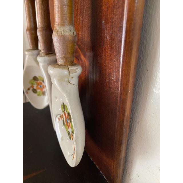 This wall Decoration is a Kitchen boxes set, for Coffee, Salt and Sugar boxes. You haved hanged some ceramic and wood fork...