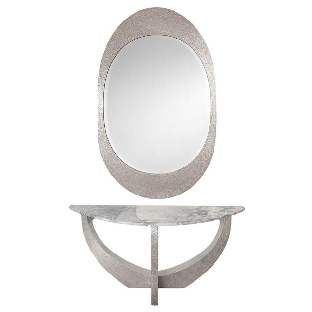 A striking and sculptural pair of American contemporary consoles with matching oversized oval mirrors, executed in...