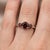 This elegant ring features a timeless trio of Garnet gemstones, admired for their deep red hue and rich, captivating...