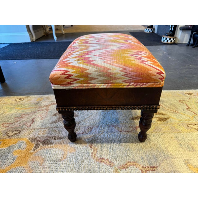 This is an antique footstool. The upholstery is newer. The wood is mahogany. It is a very pretty stool.