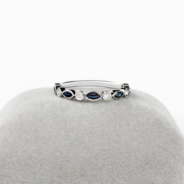 This elegant blue sapphire and diamond band features alternating marquise-cut Ceylon Blue sapphires and brilliant round...