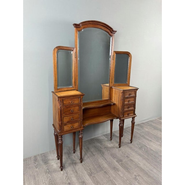Elegant and large Louis XVI style wooden dressing table with a triptych mirror. It features a large central mirror...