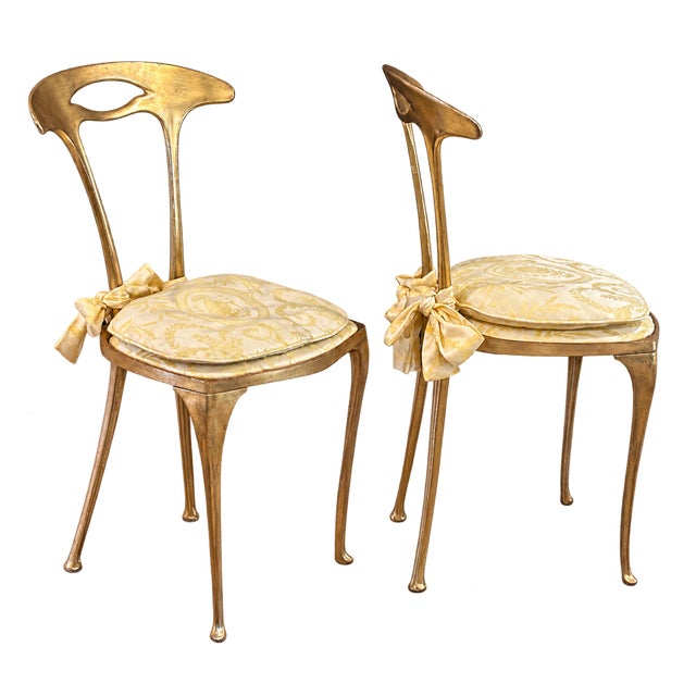 An elegant and versatile pair of vintage Italian side chairs by Palladio featuring sculptural gilt metal frames. MAKER'S...