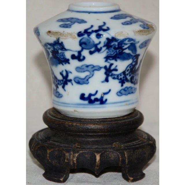 Blue hand-painted details accent this unique white Asian ceramic vessel. It is marked on the bottom of the piece. The...
