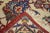 An upright, elliptical 20-point red arabesque medallion employs a straw and navy layered sub-medallion, on the old ivory...