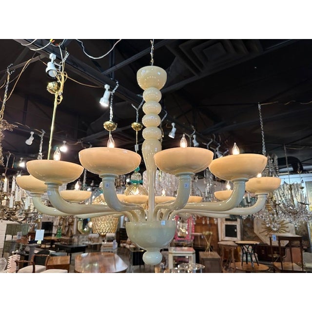 The Modern 12 Arm Ivory Murano Glass Chandelier is a stunning fixture that adds elegance and sophistication to any room....