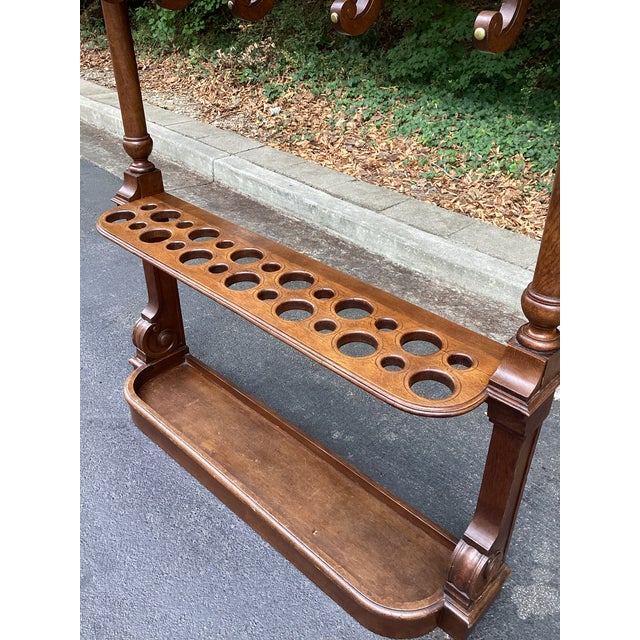 Great piece, with a carved crest, turned columns and two tiers of scrolling coat hooks. The lower rack has openings for up...