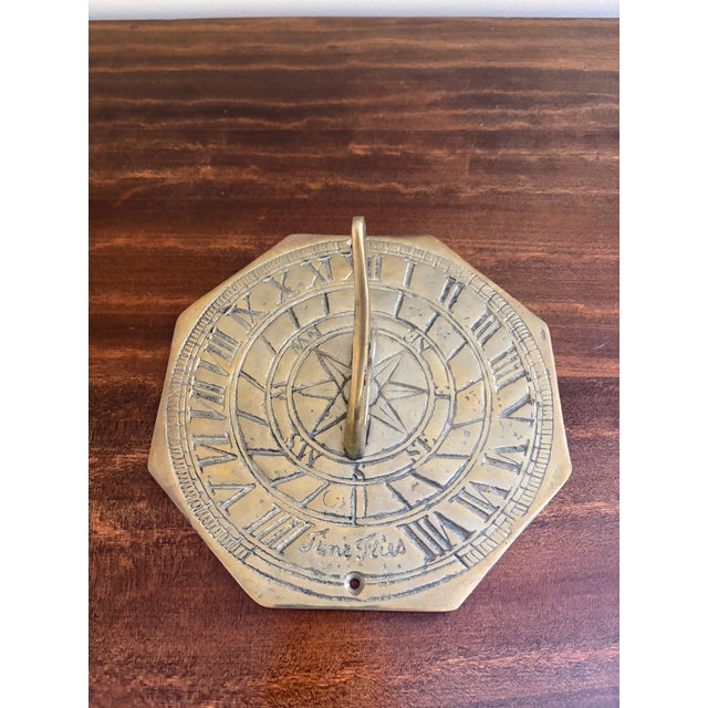 A stunning vintage brass garden sundial reading "Time Flies." USA, Late 20th Century Measures: 7.38"W x 7.38"D x 4"H Good...