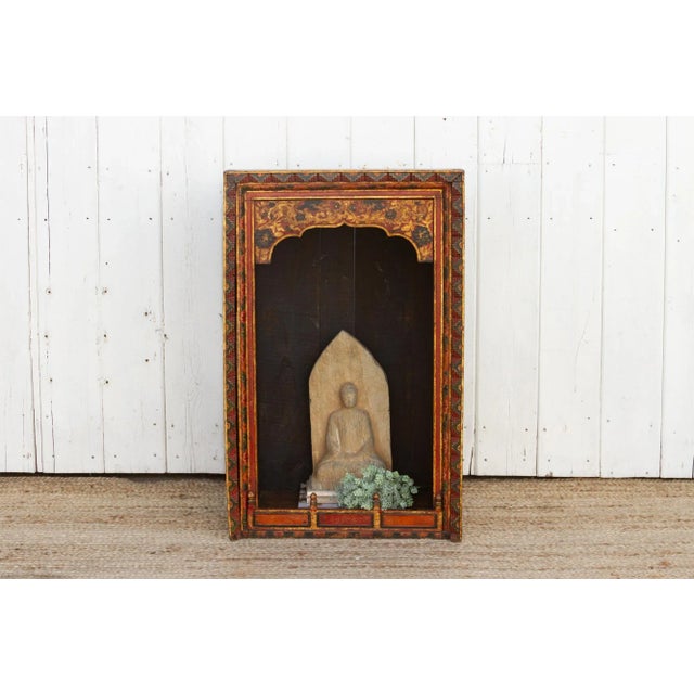 A lovely antique Tibetan painted shrine. It features an arched shaped opening with intricately hand painted dragons and...