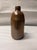 Elevate your space with this exceptional antique salt-glazed brown stoneware utility bottle, dating to the late 19th or...