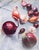 This oil painting captures a vibrant arrangement of various onions, showcasing their rich colors and textures against a...