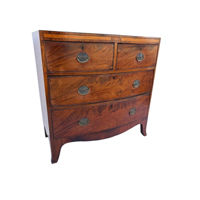 A George IV English Bow Front Chest of 4 Drawers. Exceptional wood grain to the front. Satinwood Inlaid stripe on the top...