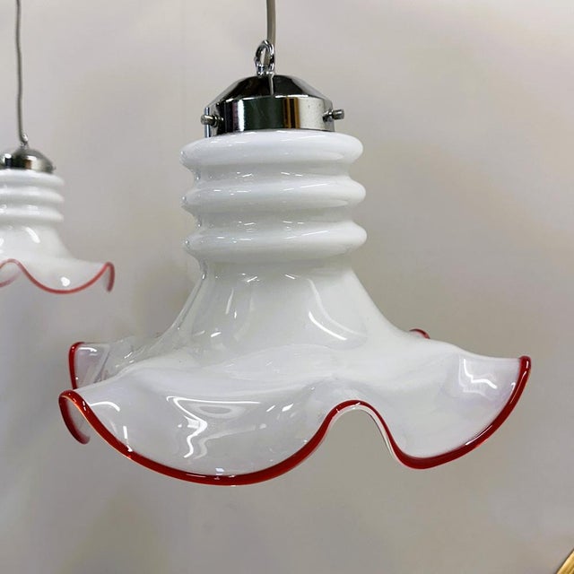 Charming pair of Italian Murano glass pendant lamps from the 1970s.Each light features a delicately hand-blown white...