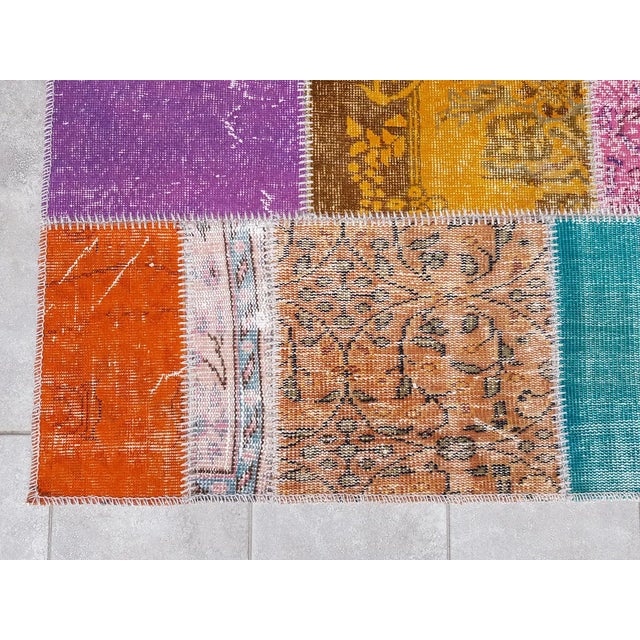 This is a vintage Turkish Oushak rug from the Mid 20th Century. The piece was hand-knotted.