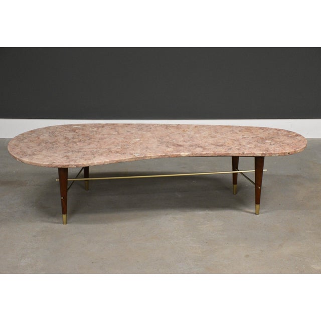 A mid century modern cherry tapered leg coffee table with polished brass octagonal stretchers and a biomorphic kidney...