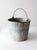 This vintage galvanized metal bucket features a classic utilitarian design with a curved handle for easy carrying....