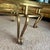 An elegant vintage gilt-iron coffee table featuring a beautifully curved wrought-iron base with scroll legs and a thick...