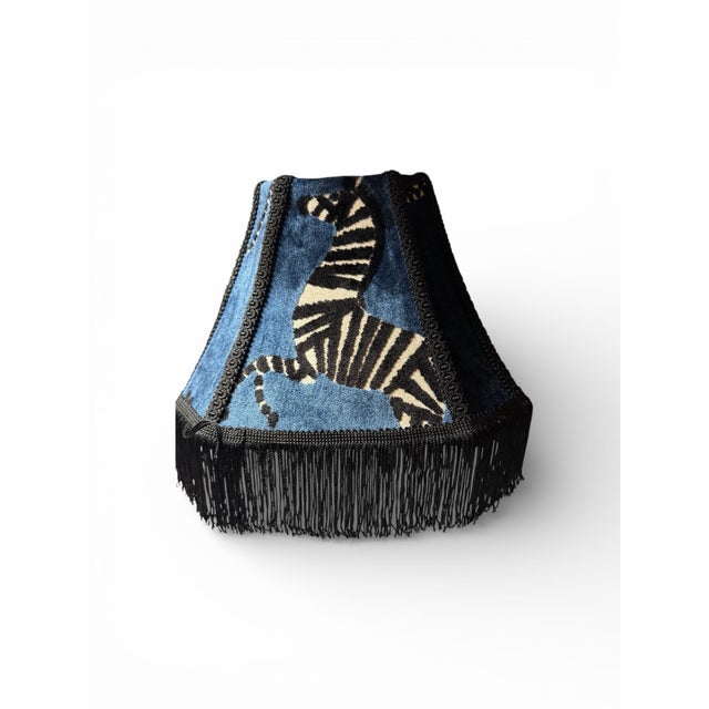 A striking custom lampshade crafted from luxurious sapphire “Regal Zebra” velvet fabric, featuring a bold black zebra...