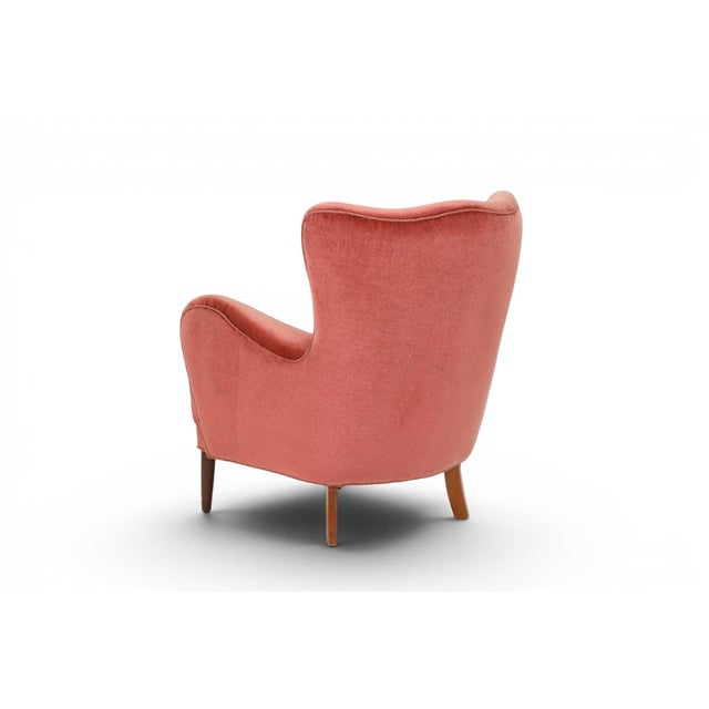 A rare and beautifully preserved 1930s Danish lounge chair retaining its original rose velour upholstery. The deep,...